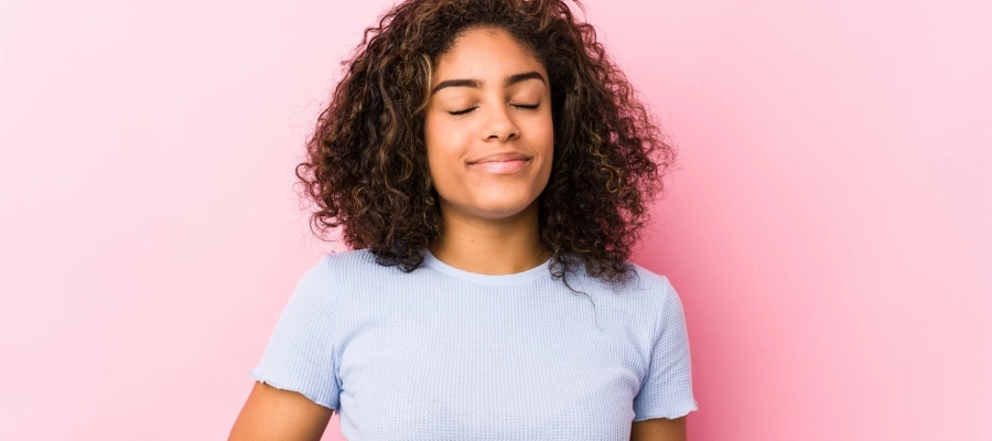 jovem negra com a mão na barriga e expressão de alívio