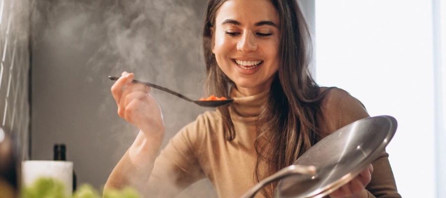 jovem cozinhando no fogão com a colher na mão