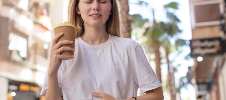 mulher sentada na rua com a mão na barriga
