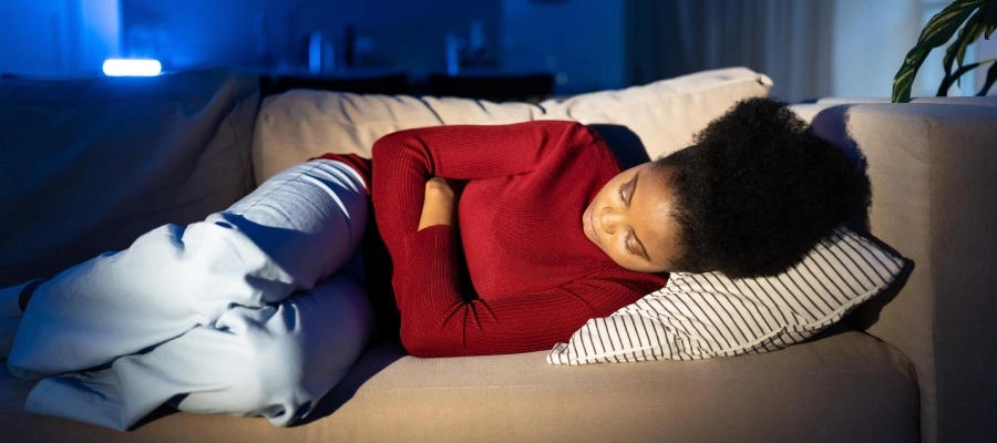 mulher deitada no sofá com má digestão a noite