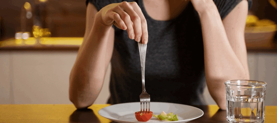 mulher sem apetite segurando um garfo