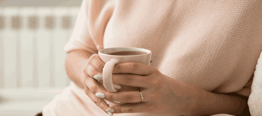 mulher segurando chá para o estômago