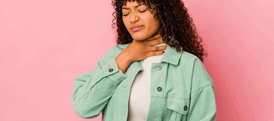 jovem com a mão no pescoço e na barriga e sensação de que a comida não desce